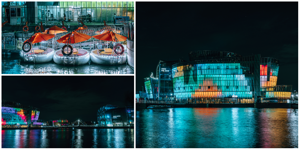 Combination of 3 photos, upper left is a photo of floating tables with orange umbrellas on the Hangang River at Sebitseom, bottom left is a photo of various colorfully lit up buildings at Sebitseom with the Hangang River in the foreground, and on the right is more lit up buildings of Sebitseom along the Hangang River 