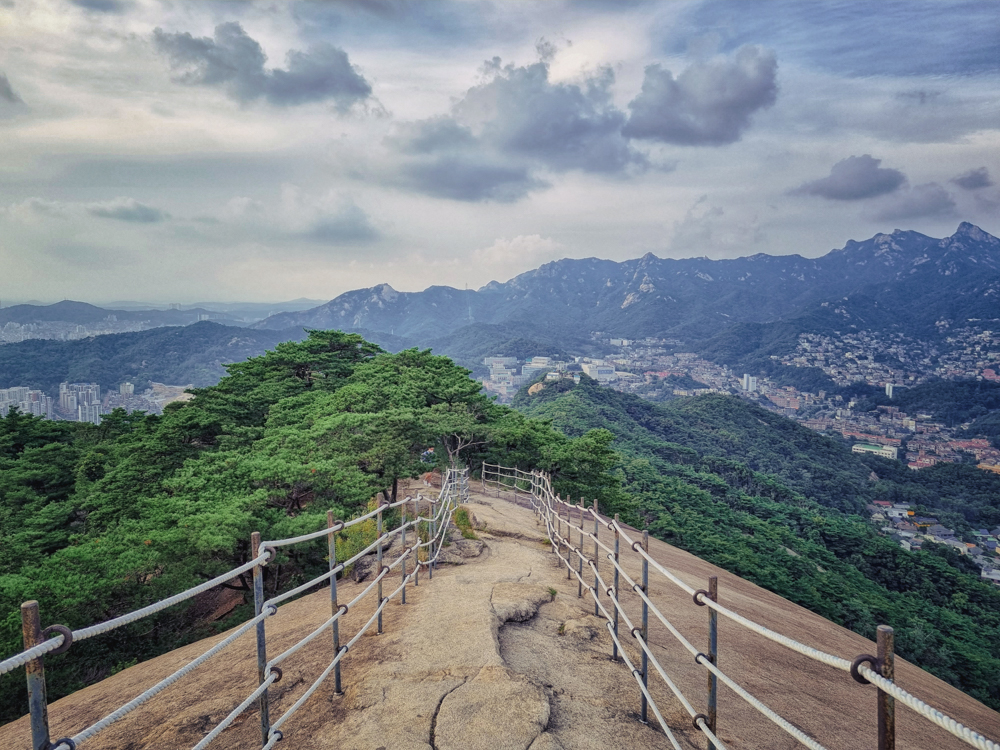 仁王山登山步道，两旁有栏杆，背景可以见到首尔的景色