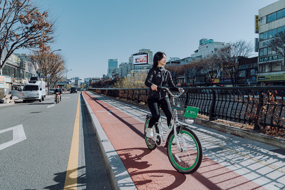 청계천 자전거도로에서 한 여자가 자전거를 타고 있다.