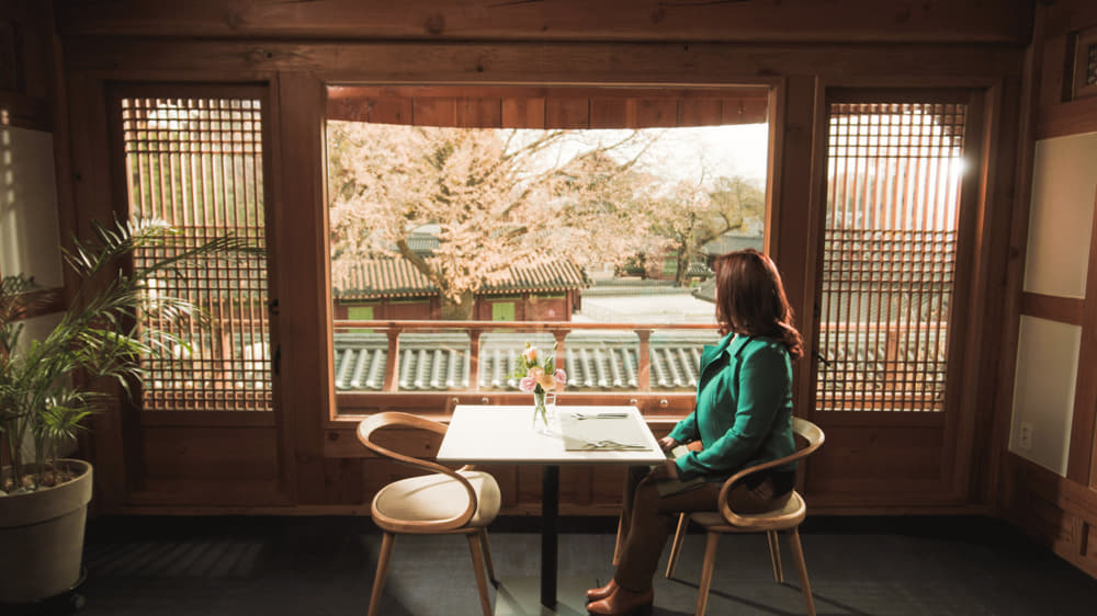 A woman sitting and looking out the window of Mish Mash.